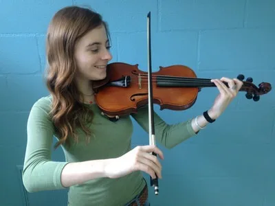 Girl holding violin with the WAVE chinrest.
